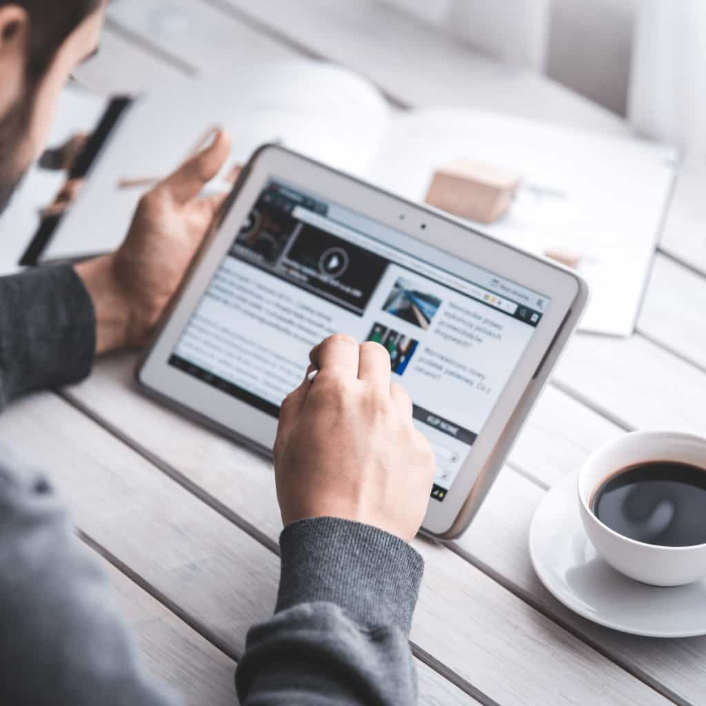 Person reading Shopify blog articles on a tablet